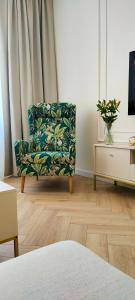 a living room with a chair in front of a window at Apartamenty Centrum Sobieski in Wałbrzych
