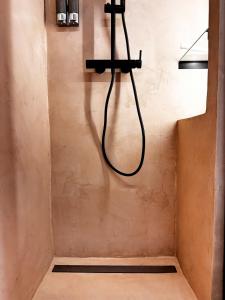 a shower with a hose hanging on a wall at VUT La Casa de la Sierra in El Barraco +15 photos