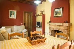 a living room with a table and a fireplace at Rural Montes Málaga: Lagar Don Sancho in Málaga