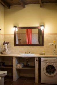 a bathroom with a sink and a washing machine at Rural Montes Málaga: Lagar Don Sancho in Málaga