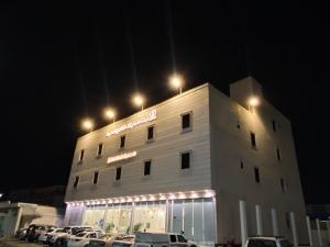 a building with cars parked in a parking lot at night at أجنحة دارك للشقق المخدومة - Ajnihat Dark Serviced Apartments in Ad Dawādimī