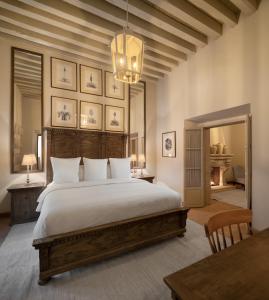 a bedroom with a large bed and a chandelier at Casa Alondra in Morelia +18 photos