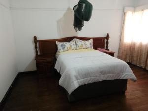 a bedroom with a large bed with white sheets and pillows at Elgin Guest in Harare