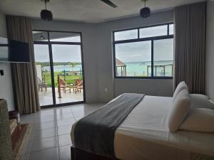 a bedroom with a bed and a view of the ocean at Blue Caribe Bacalar Front Lagoon in Bacalar