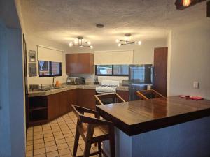 a kitchen with a table and chairs and a refrigerator at Blue Caribe Bacalar Front Lagoon in Bacalar