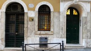 two green doors on the side of a building at Apartment Julia Guesthouse in Rome