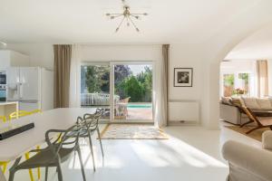 a kitchen and living room with a table and chairs at Elegant Pool Bungalow - Vienna City Limit in Hennersdorf