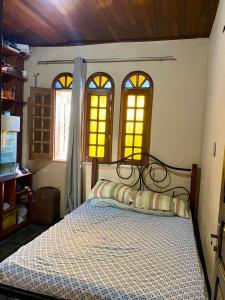 Un dormitorio con una cama y tres ventanas. en Maravilhosa Residência perto da Cop, en Belém