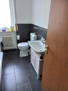 a bathroom with a white toilet and a sink at Nicky's Place in Nürnberg