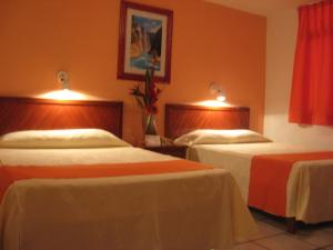a hotel room with two beds and two tables at Quinta Mar in Ciudad Valles