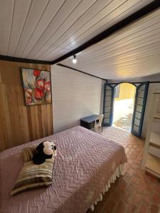 a teddy bear sitting on a bed in a room at Morada do Sol- Kitnet 01 in Imbituba