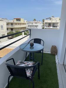 a table and chairs on a balcony with a view at Stadium Apt in Kos