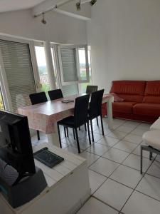 a living room with a table and chairs and a couch at T3 WALIBI in Estillac