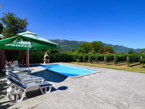 a swimming pool with a green umbrella and lounge chairs and an umbrella at Villa Granny Nevenka near MAKARSKA in Dusina