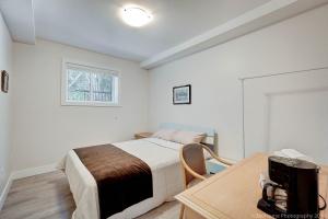 una camera da letto con un letto, una scrivania e una finestra di T Bright & Cozy Queen & Sofa Beds Room Ensuite a West Vancouver