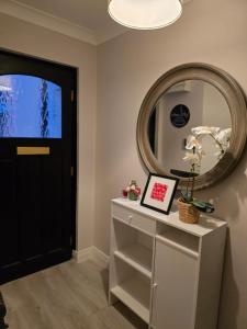 a hallway with a mirror and a white dresser at Dreams and Homes in Dublin- Entire home in Hartstown