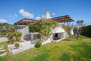 una casa bianca con un prato di Casaalmare a Mola di Bari