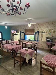 a restaurant with tables and chairs and a chandelier at Villa Di Verona Charm Hotel in Guarujá