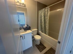 a bathroom with a toilet and a sink and a shower at Cozzy & Brand New Apartment, Near Banff Hwy in Calgary +17 photos