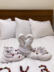 two swans made out of towels on a bed at Isis Pyramids View Inn in Cairo