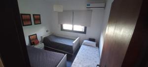 ein kleines Schlafzimmer mit einem Bett und einem Fenster in der Unterkunft Casa Amsterdam in Villa Carlos Paz + 9 Fotos