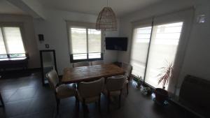 ein Esszimmer mit einem Holztisch und Stühlen in der Unterkunft Casa Amsterdam in Villa Carlos Paz