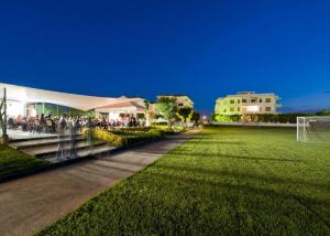 a group of people sitting under a tent on a soccer field at Residence Nova Marina in Sottomarina