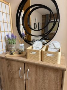 a bathroom vanity with a round mirror and baskets at Alpine Myth in Sankt Anton am Arlberg +36 photos