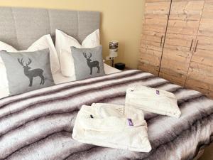 a bedroom with a bed with two deer pillows at Alpine Myth in Sankt Anton am Arlberg