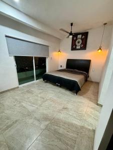 Un dormitorio con una cama y un reloj en la pared. en Casa Rubi, en Acapulco