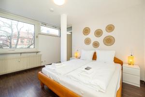 ヴュルツブルクにあるDowntown Retreatの白いシーツが敷かれた大きなベッドのある寝室