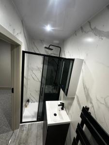 a white bathroom with a sink and a shower at Abbey House in Waltham Abbey