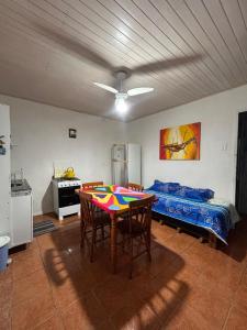 a kitchen with a table and chairs and a refrigerator at Morada do Sol- Kitnet 01 in Imbituba