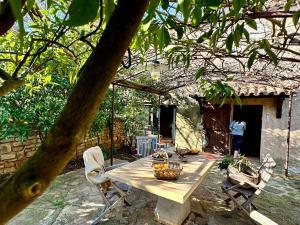 a wooden table and chairs in a yard at Rez de jardin au calme dans le parc des calanques in La Ciotat