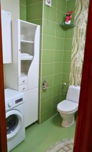a bathroom with a toilet and a washing machine at Apartament Zielona Przystań u Agi in Ełk