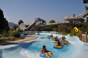 a group of people riding down a water slide at a water park at Rez de jardin au calme dans le parc des calanques in La Ciotat