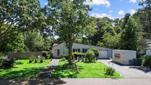 a house with a tree in the yard at MacArthur House in Hauppauge