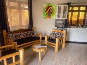 a living room with a couch and a chair at 5 Empologoma Cottage - Benanda Forest Resort in Masaka +23 photos