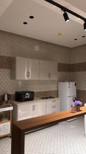 a kitchen with white cabinets and a white refrigerator at Twilight apartment in Buraydah