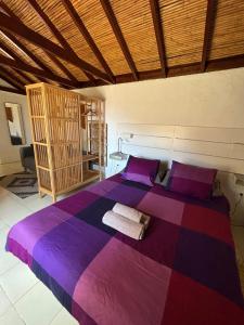 a bedroom with a large purple bed with purple pillows at Casita El Molino im grünen Valle Gran Rey in Valle Gran Rey