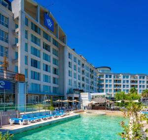 a hotel with a pool in front of a building at Apart , DEPARTAMENTO CONDOMINIO BAHIA GRANDE NORDELTA , TIGRE , CON BALCÓN Y VISTA A LA Bahia in Tigre