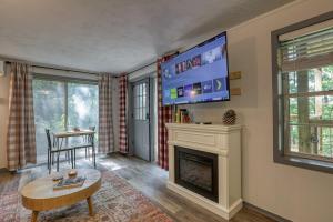 a living room with a fireplace and a flat screen tv at Moose Suite 1King Bed 1Queen Sofa bed + Hot Tub in Gatlinburg