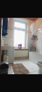 a bathroom with a window and a sink and a toilet at Ferien Wohnung Elmaci in Itzehoe +8 photos