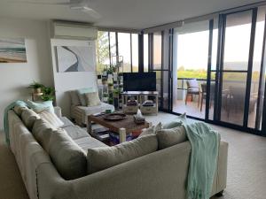 un soggiorno con un divano e una televisione di Views & Sounds of the Sea Bed & Breakfast -hosted by Deb a Coffs Harbour