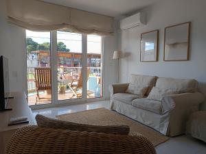 a living room with a couch and a large window at Camí Ample, Apartamento 2 hab con parking in L'Escala