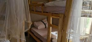 a couple of bunk beds in a room with curtains at 2 Envubu Cottage - Benanda Forest Resort in Masaka +28 photos