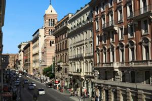 une rue de la ville avec des bâtiments et une tour de l'horloge dans l'établissement Hotel Artemide, à Rome