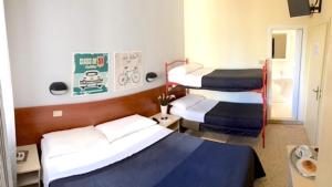 a hotel room with three beds in a room at Hotel Byron Light NUOVA GESTIONE 2024 in Riccione