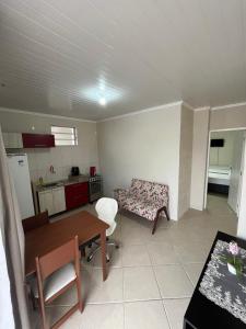 a kitchen and a living room with a table and a couch at Pousada da Jô in São Gabriel