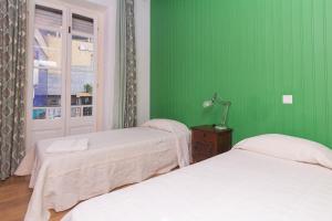 a green room with two beds and a window at Guet House Vila tejo in Vila Franca de Xira